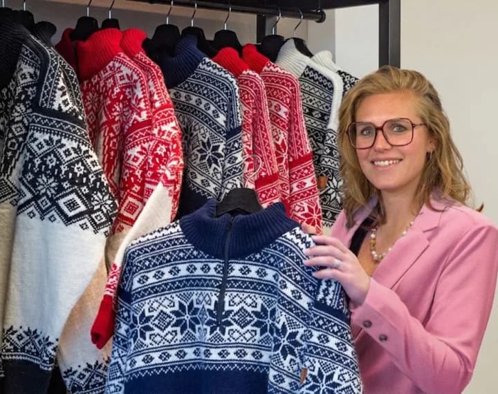 Roxy met een rek gebreide truien in het magazijn